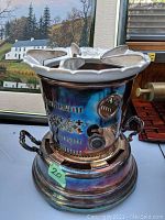 Front view of complete chaffing stove on base showing top grid and side handles