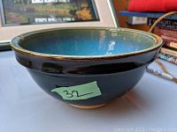 Side angle of the pottery bowl showing blue glaze exterior and rim details