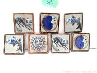 Seven handmade and hand painted Mexican ceramic tiles arranged in two rows. Designs include cats, fish, the sun, and the moon in muted blues, grays, browns, and whites. Each tile is 7 cm square with terracotta edges.