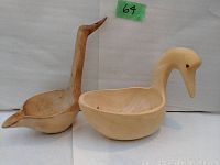 Two wood ladles carved in the shape of birds, side by side, front view showing bowls and necks