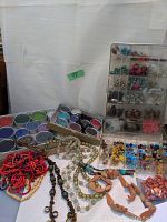 Wide view showing multiple strands of colorful beads and bead containers
