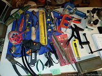 Top view of all tools arranged on table, showing clamps, glue gun, hand drills, files, and other hand tools.