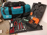 Makita brand tool bag beside hand tool set and Black & Decker drill in case