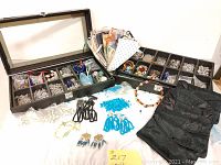 Full overview of the craft supplies including storage box, trays with metal findings and beads, decorative beads in multiple colors, and small gift bags.