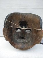 Back view of carved wooden mask showing hollow interior and string mount