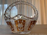 Side view of the amber cut crystal basket with floral patterns showing the handle and decorative cut glass.