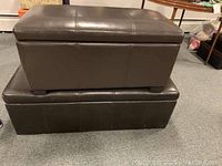 Two dark brown faux leather storage chests stacked, showing size difference and exterior condition.