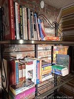 Two photos showing multiple books arranged on metal shelves against a brick wall. Various titles and genres visible.