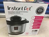 Box of Instant Pot 6-in-1 multi-use programmable pressure cooker showing brand, model, and features.