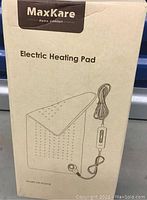Box showing MaxKare branded electric heating pad with image and model number HPA-F01210