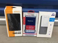 Three boxed items: XTPower-20000 power bank, Gigastone 10000mAh power bank, and battery case for Galaxy Note 10.