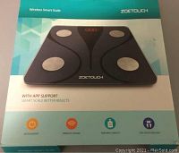 Box of Zoetouch Wireless Smart Scale showing front design, app support, and features like auto shutdown, wireless phone compatibility, and high max capacity.