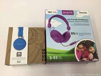 Lot showing both headphone boxes: purple iSound HM-310 wired kid headphones and blue Tensley X2 wireless headphones