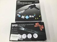 Boxes of the 5pcs telescoping tool kit and mini portable vacuum cleaner showing product branding and packaging