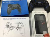 Photo showing Doubleshock 4 Wireless Controller box, an out of box controller, and packaged phone case with classic 3G games.