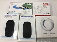Photo showing two wireless mouse boxes, a 2.5" HDD external case box, SQ16 mini DV camera box, and selfie ring light box.
