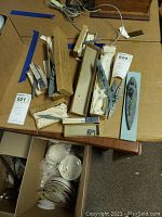 Top-down view of three gray miniature naval boat models along with original boxes and padding on a table surface, showing details and protective materials.