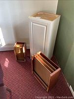 Tall white cabinet standing upright with two flat file cabinets on a carpeted floor, showing overall item condition and style.
