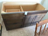 Full view of the Brookhaven bathroom vanity showing the front with drawer and cabinet compartments, wood finish, and missing countertop or sink.