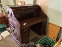 Front view with roll-top open showing small upper drawers and desktop area.