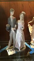Front view of Lladro wedding couple figurine showing bride and groom in formal attire with groom holding a top hat.