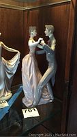 Front view of Lladró dancing couple figurine within display cabinet