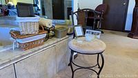 Overview of vanity chair, baskets, candles, and ceramic planter on corner ledge, with mirror background