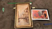 Two framed pieces side by side: Louis M Cevetello painting and Gone with the Wind puzzle