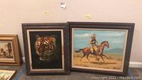 Two framed wall art pieces, tiger portrait on left and cowboy on horse on right