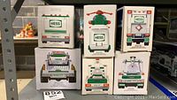 Stacked boxed Hess collectible toy trucks and one helicopter showing rear views and packaging.