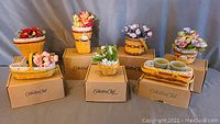 Group shot of all seven miniature baskets arranged on Collector’s Club boxes