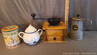 Full view of the four items: coffee mill, tea pot, coffee canister and metal coffee pot