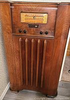 Front view of Emerson console antique radio showing wooden cabinet with vertical slats and dial, control knobs.