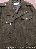 Top front side view showing dark gray jacket with multiple pockets and metallic snap buttons