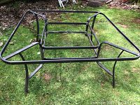 Extruded aluminum patio table frame shown on grass, no table top attached.