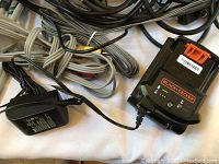 Black & Decker battery and charger with multiple cables.