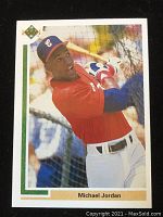 Front of the card showing Michael Jordan swinging a bat in a white and red baseball uniform.