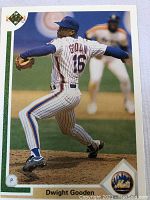 Front of Dwight Gooden baseball card in white pinstriped Mets uniform, showing him pitching on the mound.