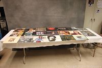 Wider shot showing full set of 20 vintage LP albums laid out on a table with various cover arts visible.
