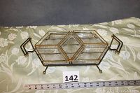 Full view of assembled relish dish set on floral fabric showing the five glass sections in wrought iron stand with gold accents