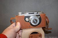 Argus MDL Anastigmay camera front view with brown leather case showing lens and part of camera body