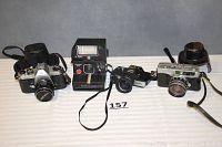 Group photo showing all four cameras side by side on white surface, including Pentax Spotomatic, Polaroid OneStep Plus, Minolta 110 Zoom, Petri 7 S.