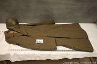 Coat and helmet arranged flat on table with measuring tape