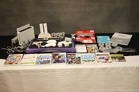 Full lot arranged on table with console, board, controllers, games and accessories
