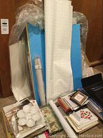 Various rolled boards or paper in blue and white, small cards, and stacks of items seen from an angle.