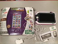 LeapPad Ultra box with tablet, charger, earbuds, and manuals laid out for display.