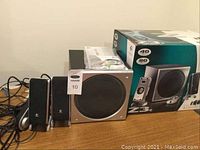Photo showing the Logitech Z3e 2.1 speaker system including subwoofer, two satellite speakers and original packaging.