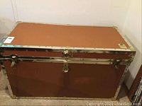 Front view of the brown cedar lined trunk with metal reinforcements and lock hardware.