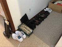 Photo showing row of ladies footwear including boots, white athletic shoes, and casual shoes lined up on the floor