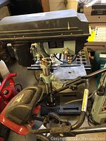 Side view of assembled drill press showing overall condition and dust buildup